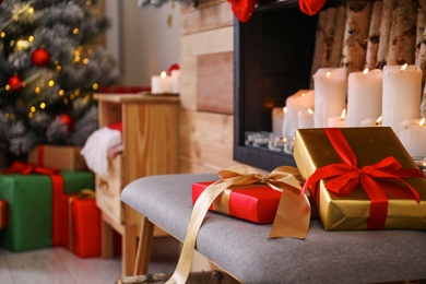Photo of Christmas gifts on chair in stylish room interior
