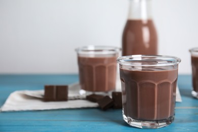 Delicious chocolate milk on light blue wooden table. Space for text