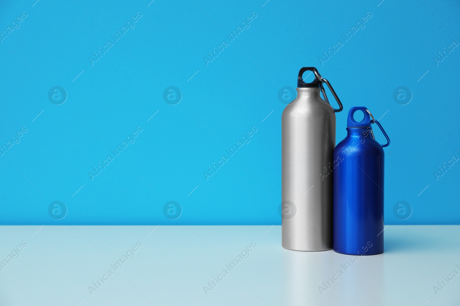 Photo of Aluminum water bottles for sports on color background. Space for text