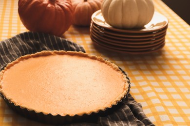 Photo of Delicious homemade pumpkin pie in baking dish on table