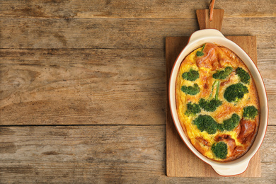 Photo of Tasty broccoli casserole in baking dish on wooden table, top view. Space for text