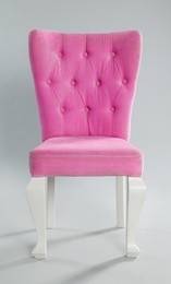 Stylish pink chair on light grey background. Element of interior design