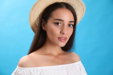 Portrait of beautiful young woman on light blue background