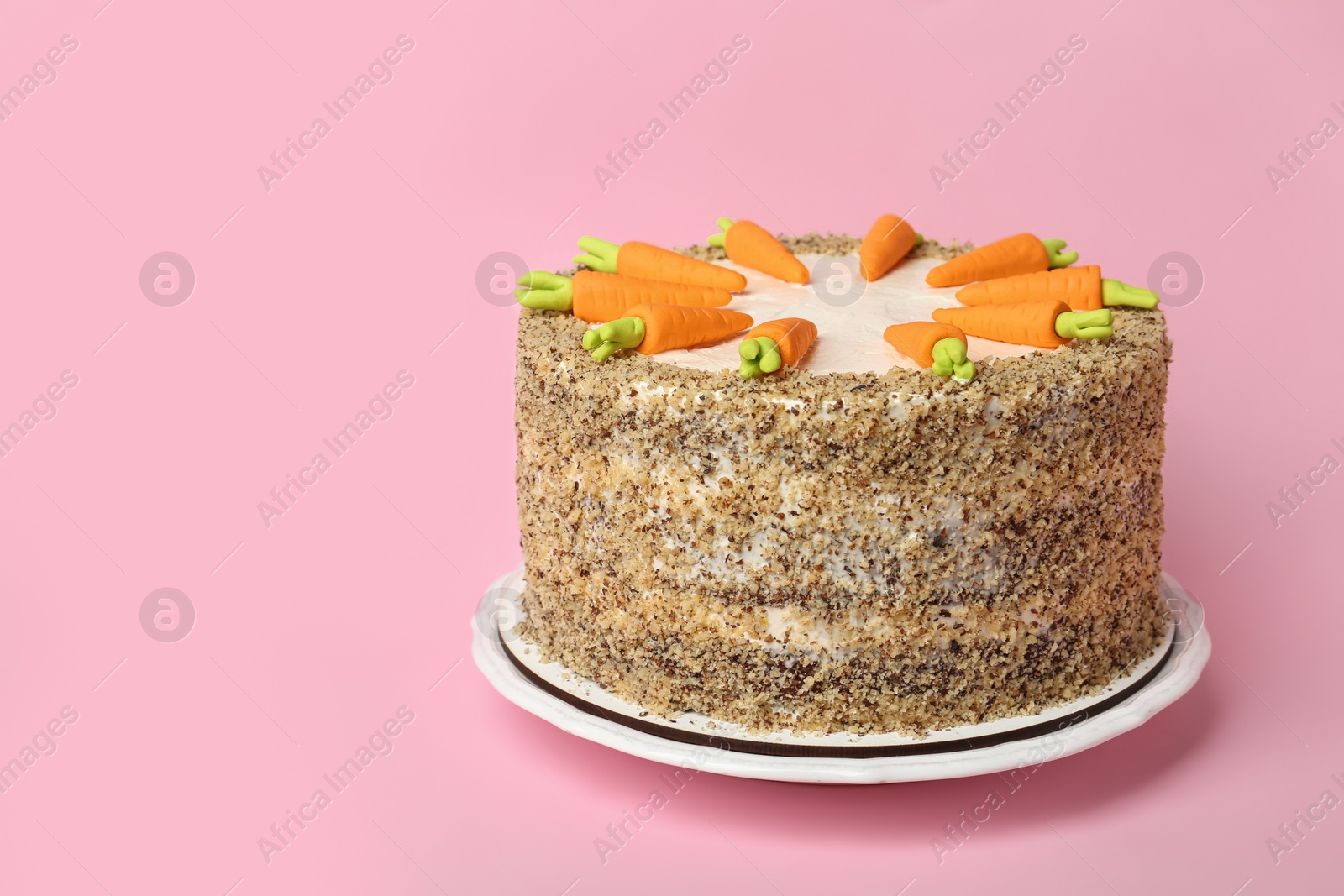 Photo of Dish with tasty carrot cake on pink background, space for text