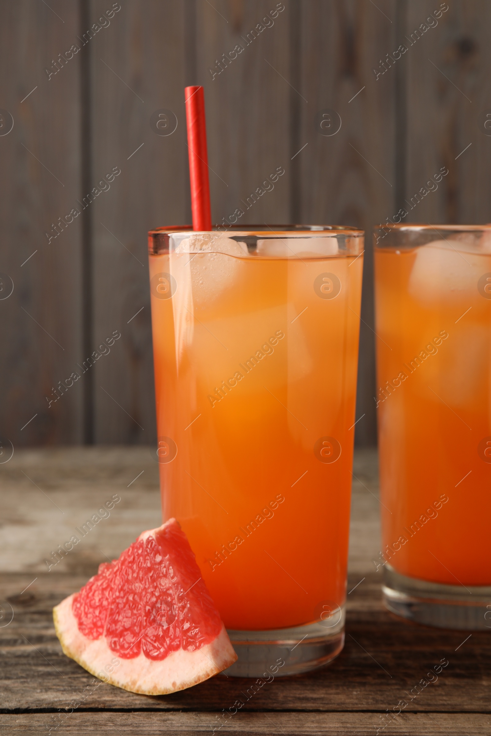 Photo of Tasty freshly made grapefruit juice and fruit on wooden table