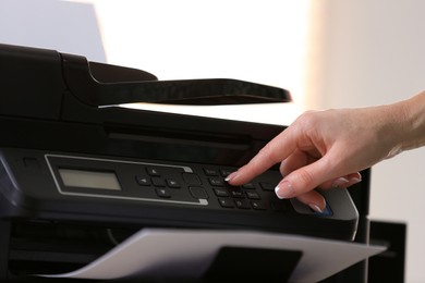 Photo of Woman using modern printer in office, closeup