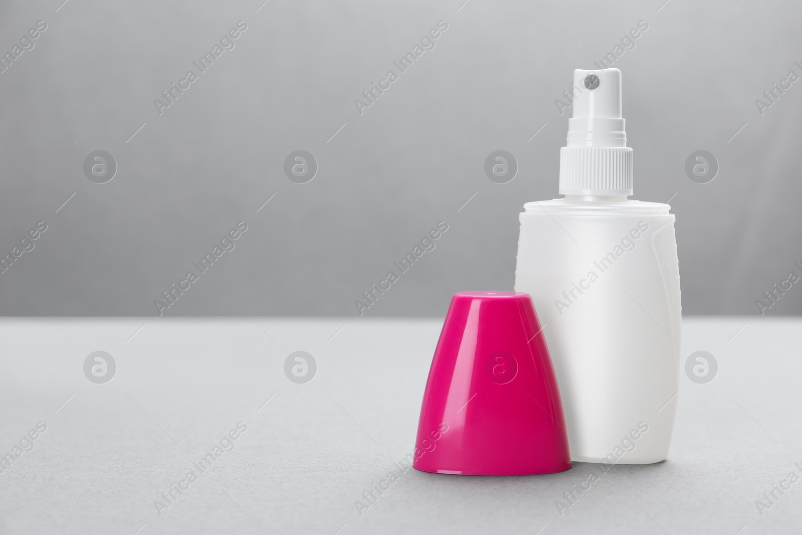 Photo of Bottle with insect repellent spray on grey background, space for text