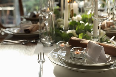 Photo of Elegant table setting with beautiful floral decor and burning candle. Space for text