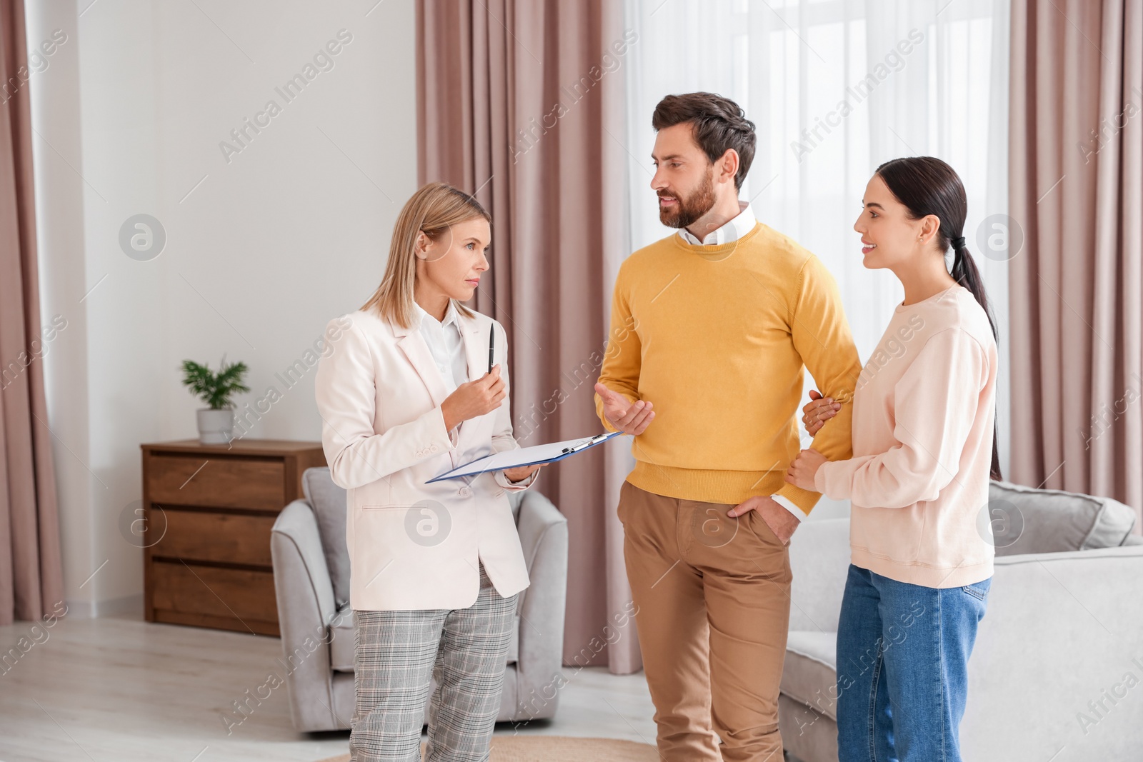 Photo of Real estate agent working with couple in new apartment