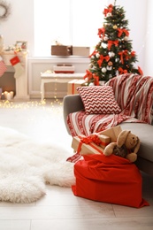 Photo of Room interior with Christmas tree and Santa's bag of gifts