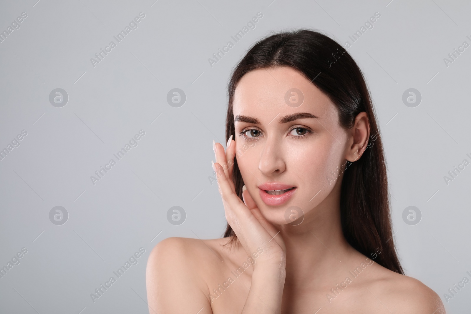 Photo of Portrait of beautiful young woman on light grey background. Space for text