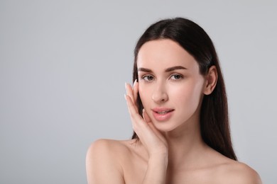 Portrait of beautiful young woman on light grey background. Space for text