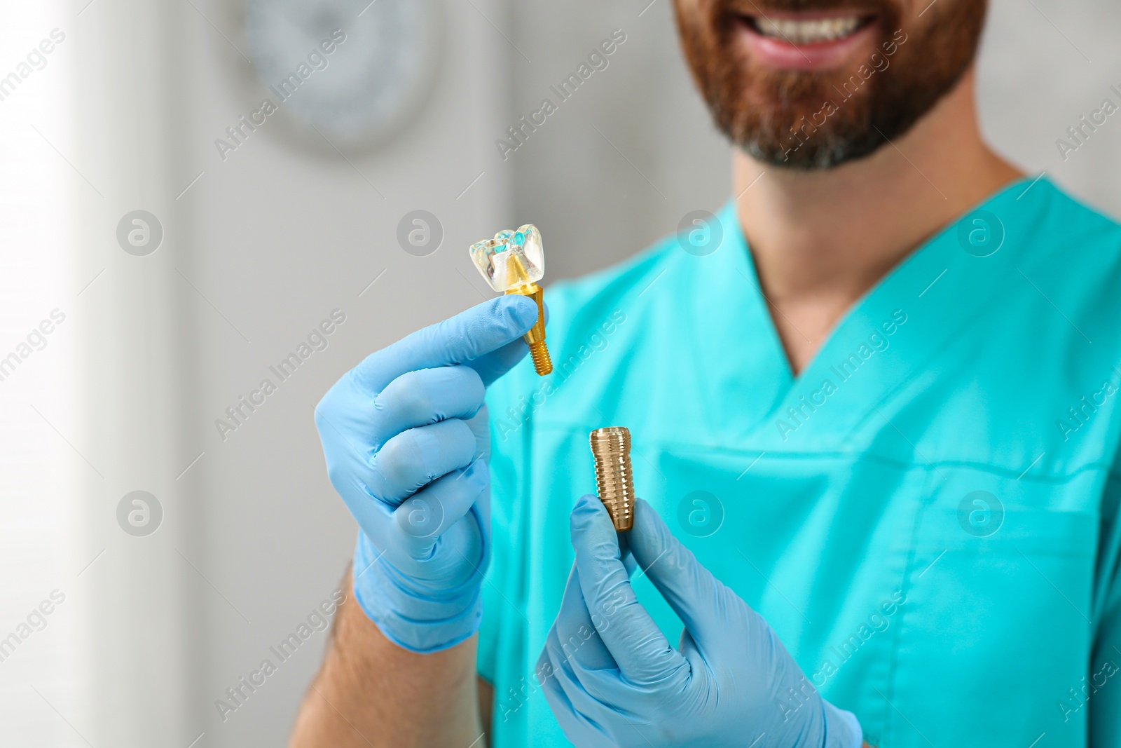 Photo of Dentist holding educational model of dental implant on blurred background, closeup. Space for text