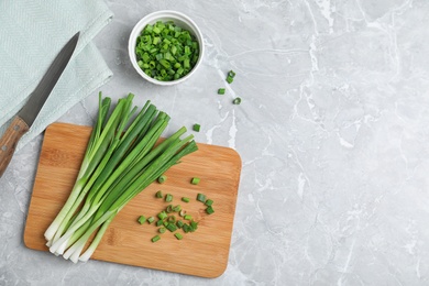 Photo of Flat lay composition with fresh green onion on marble background. Space for text