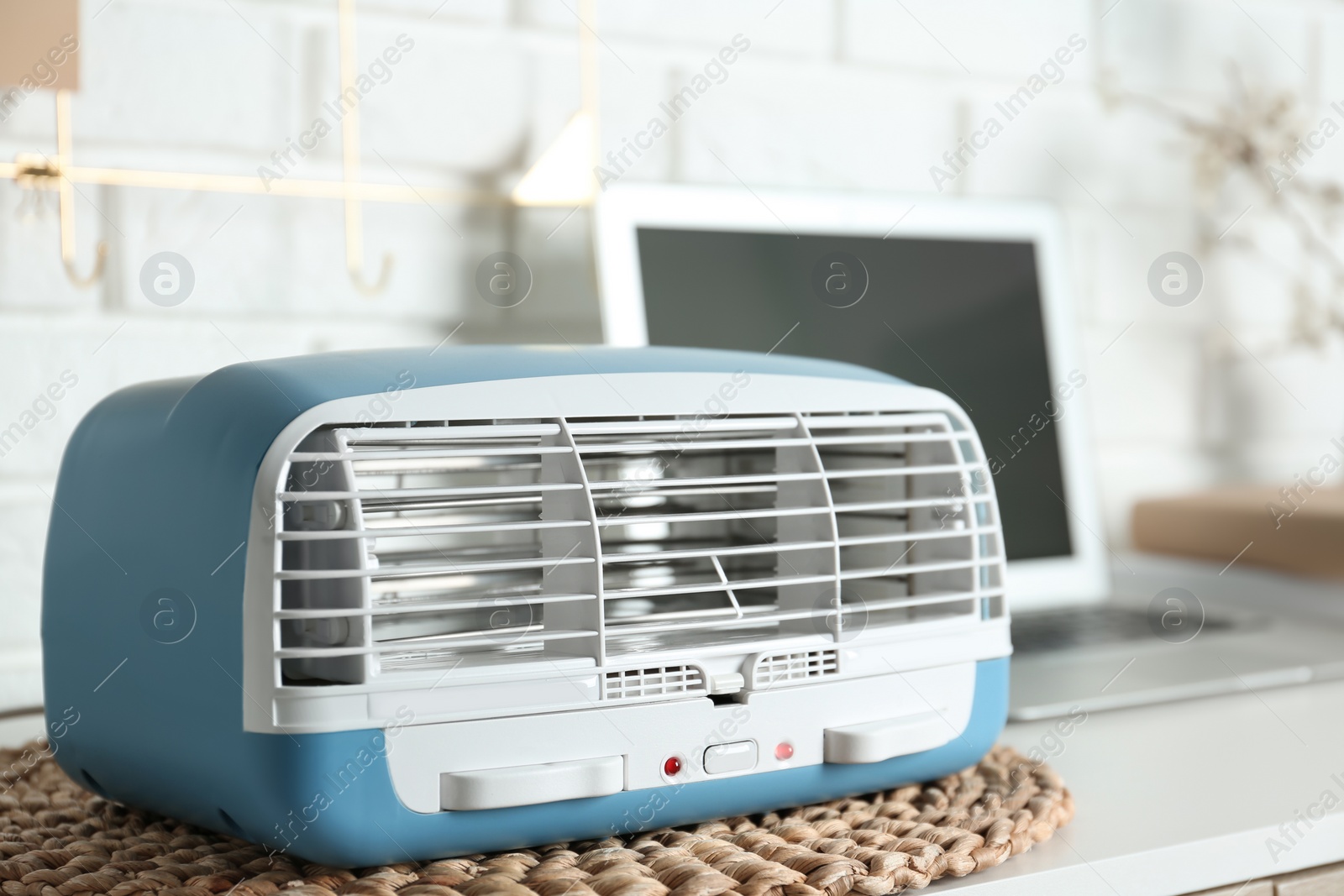 Photo of Modern air purifier on white wooden table in room, closeup