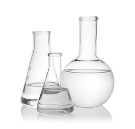 Photo of Flasks with transparent liquid on white background