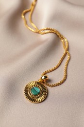 Photo of Elegant necklace on beige cloth. Stylish bijouterie