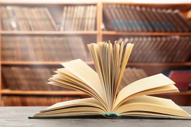 Open book on grey table in library