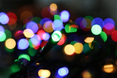 Photo of Colorful Christmas lights on dark background, closeup view