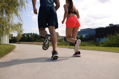 Healthy lifestyle. Couple running outdoors, low angle view