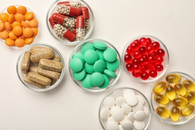 Photo of Different dietary supplements in bowls on white background, flat lay