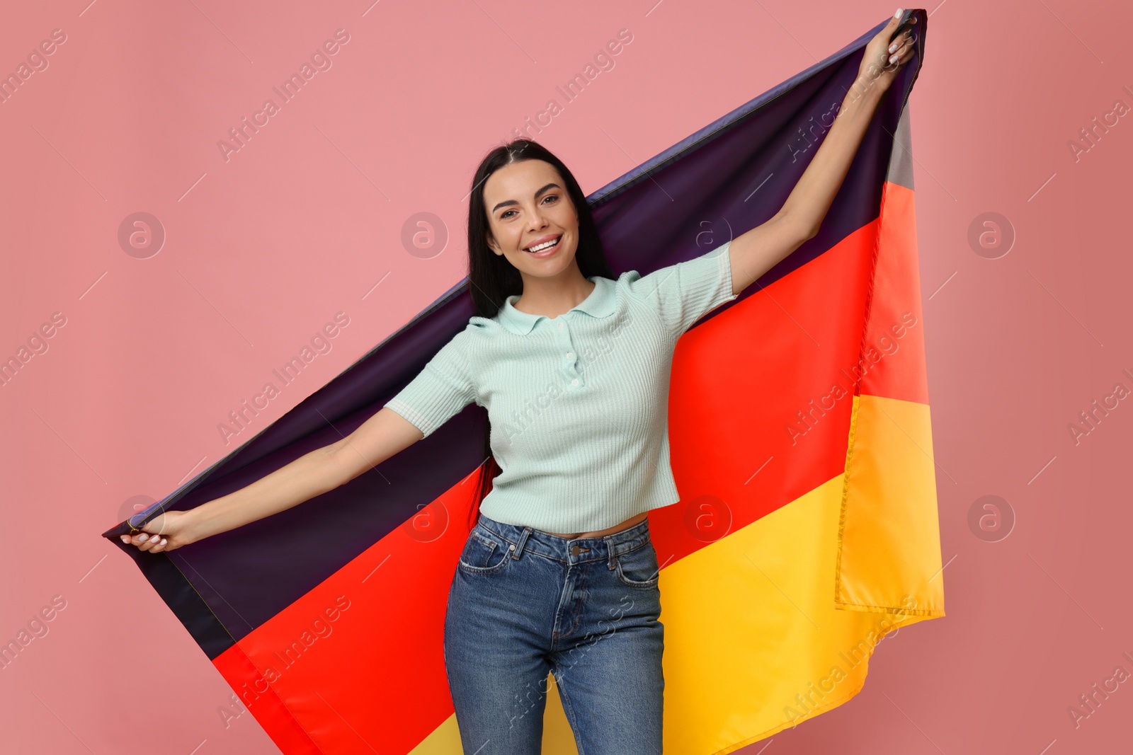 Photo of Happy young woman with flag of Germany on pink background