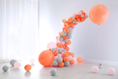 Image of Balloon garland near white wall in room. Festive decor