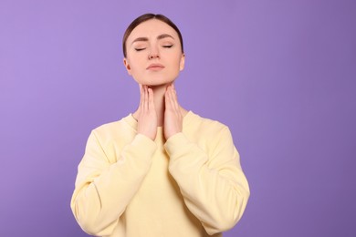 Photo of Young woman with sore throat on violet background