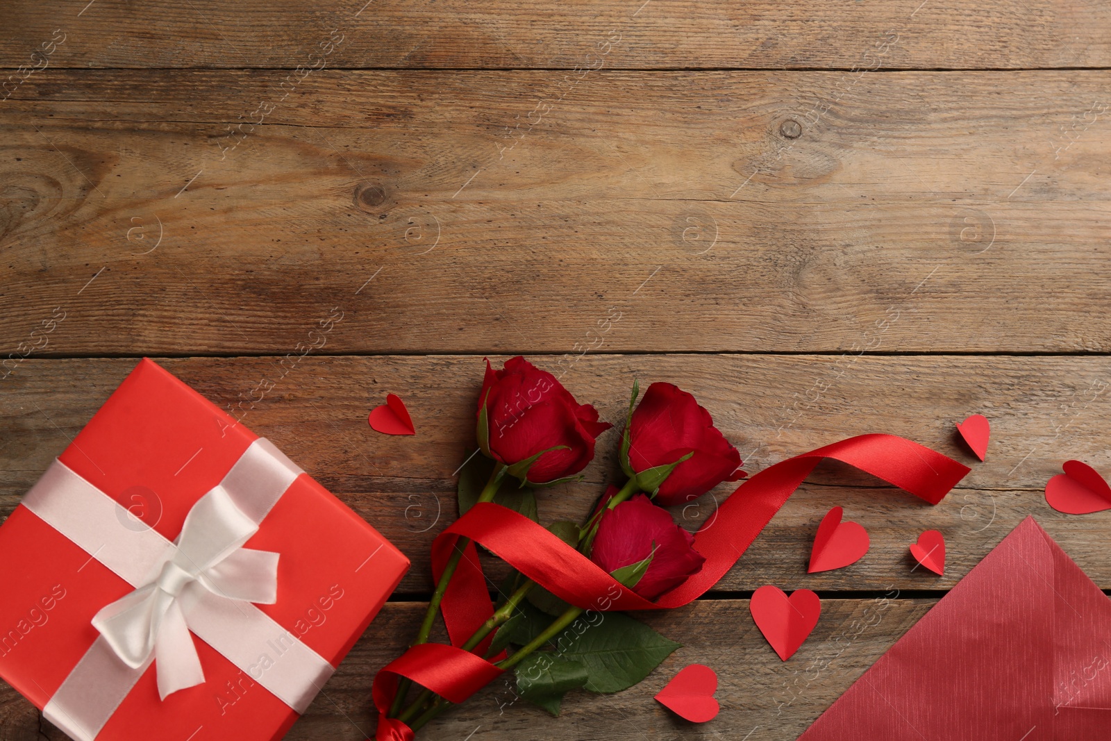 Photo of Flat lay composition with gift box on wooden table. Valentine's Day celebration