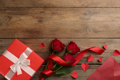 Photo of Flat lay composition with gift box on wooden table. Valentine's Day celebration