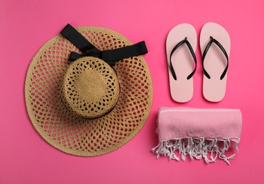 Photo of Hat, flip flops and blanket on pink background, flat lay. Beach object