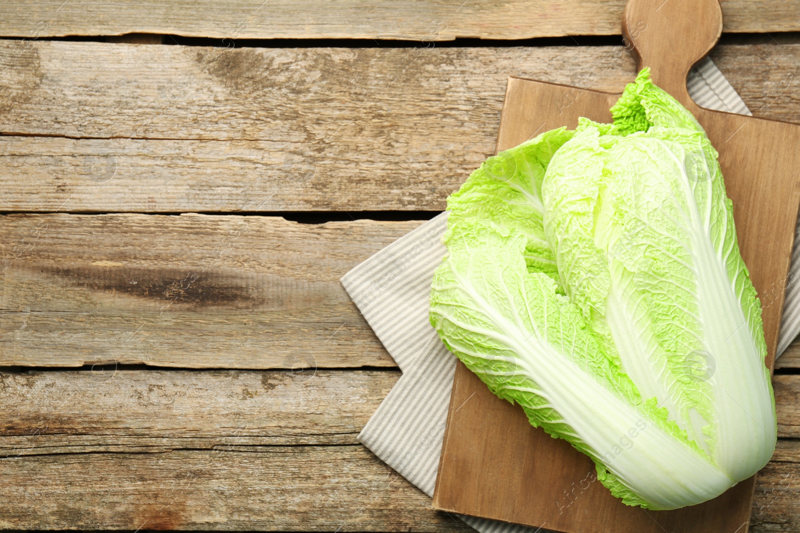 Photo of Fresh ripe Chinese cabbage on wooden table, top view. Space for text