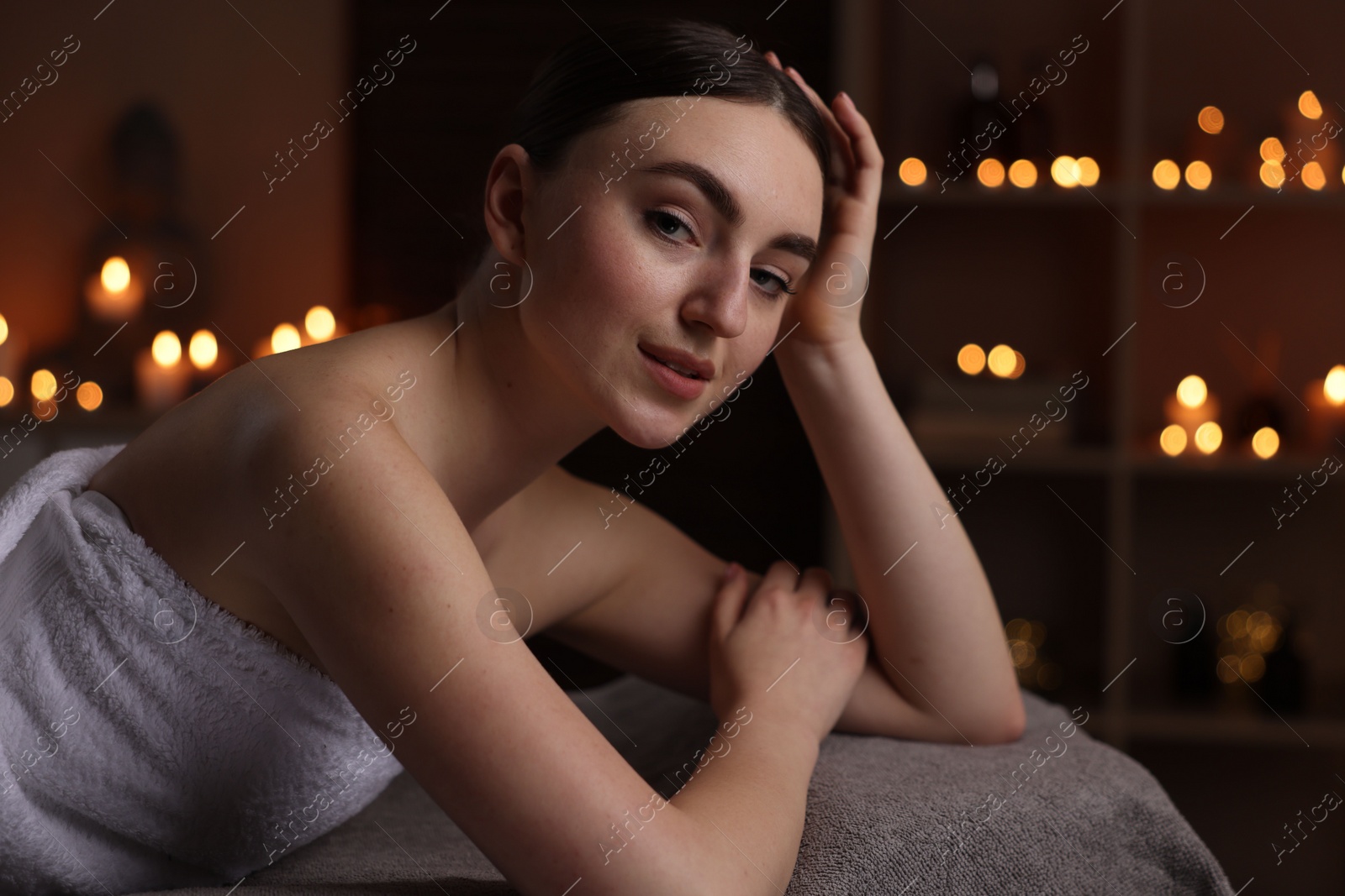 Photo of Spa therapy. Beautiful young woman lying on massage table in salon