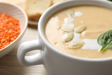 Photo of Healthy cream soup high in vegetable fats on wooden table, closeup