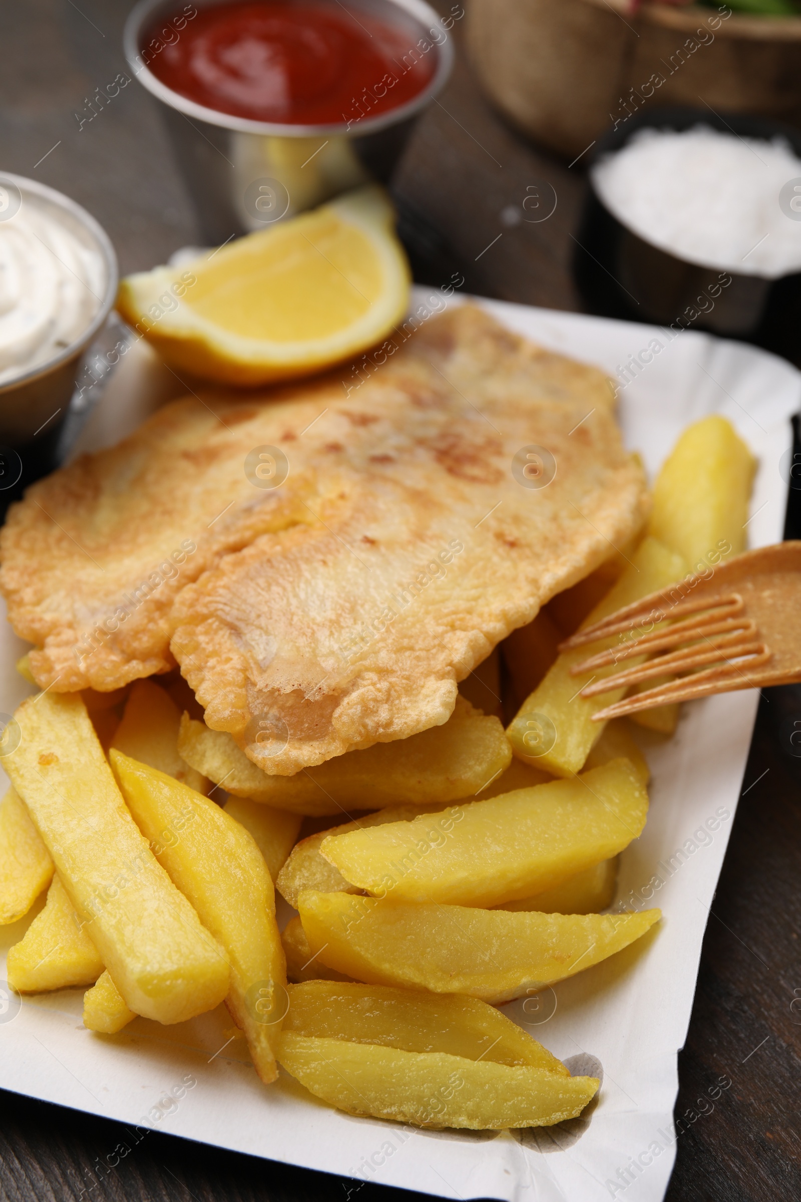 Photo of Delicious fish and chips served on table, closeup