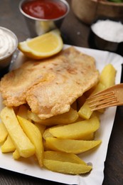 Photo of Delicious fish and chips served on table, closeup