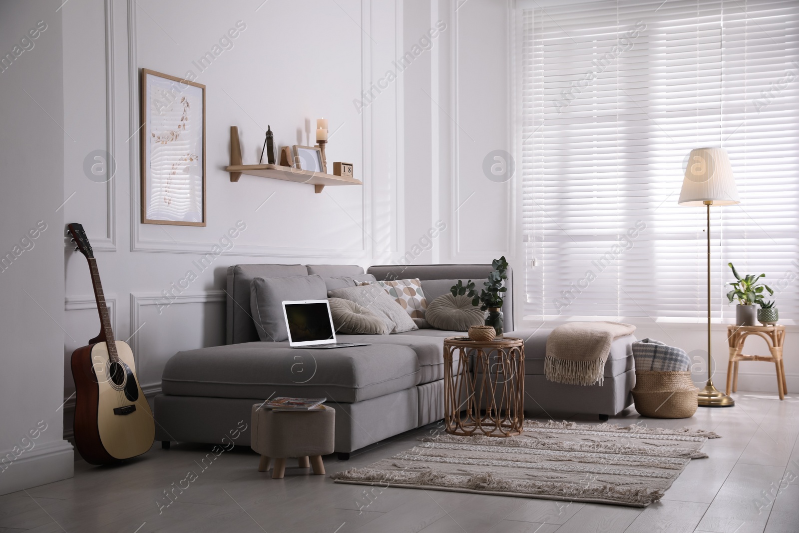 Photo of Living room with comfortable grey sofa and stylish interior elements near window