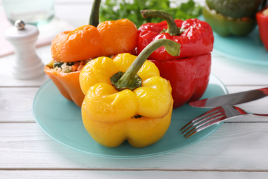 Photo of Tasty stuffed bell peppers on white wooden table
