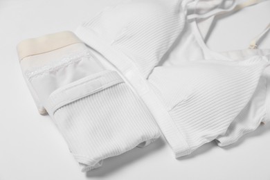 Photo of Stylish folded women's underwear on white background