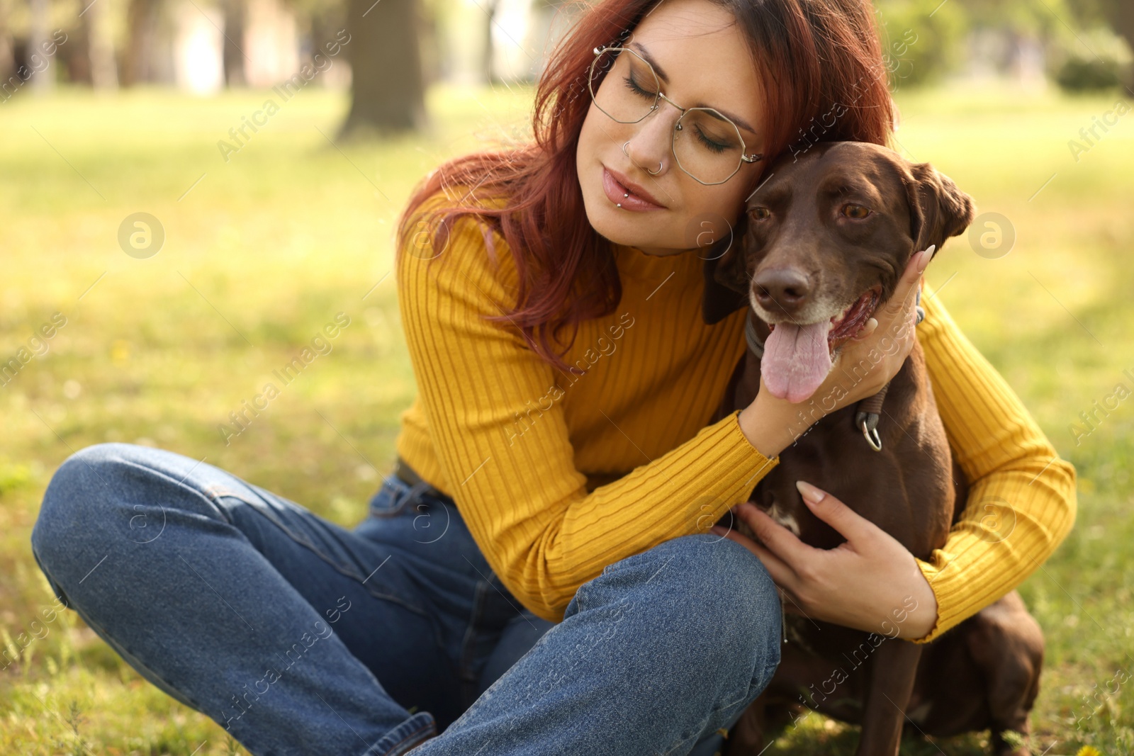 Photo of Woman with her cute German Shorthaired Pointer dog in park on spring day