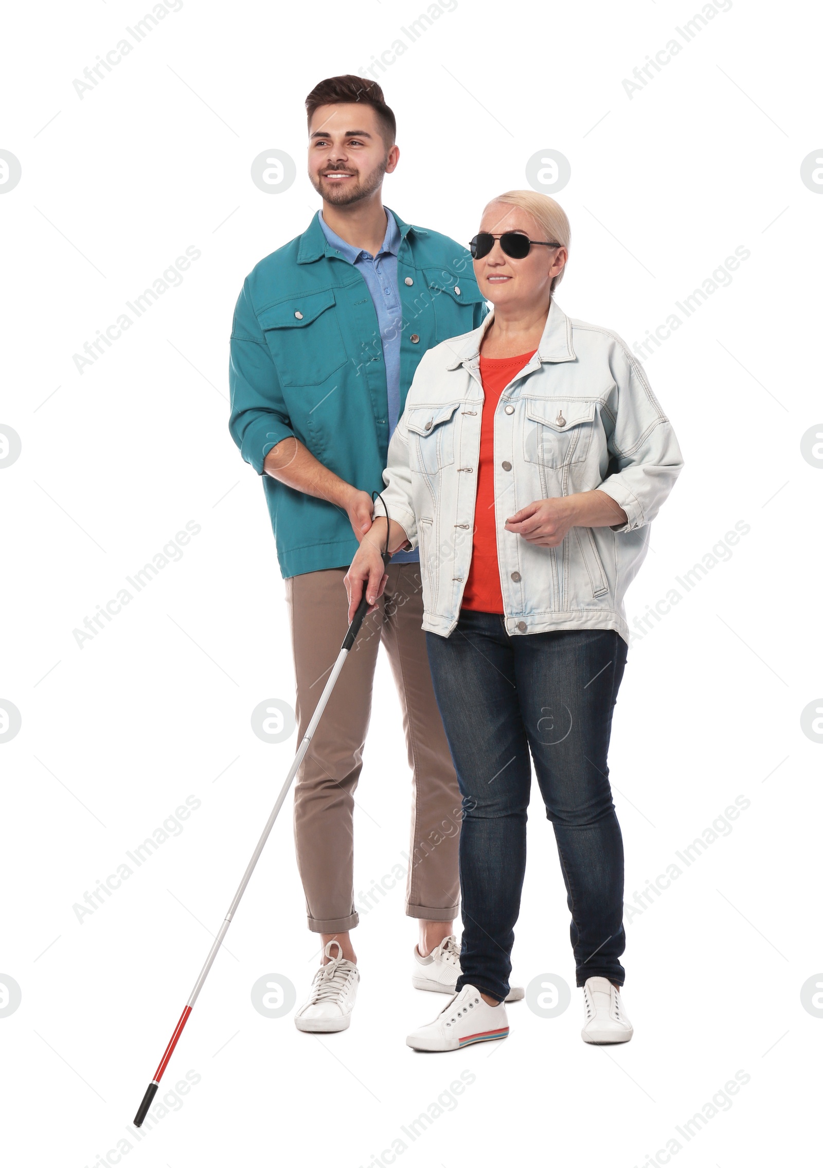 Photo of Young man helping blind person with long cane on white background