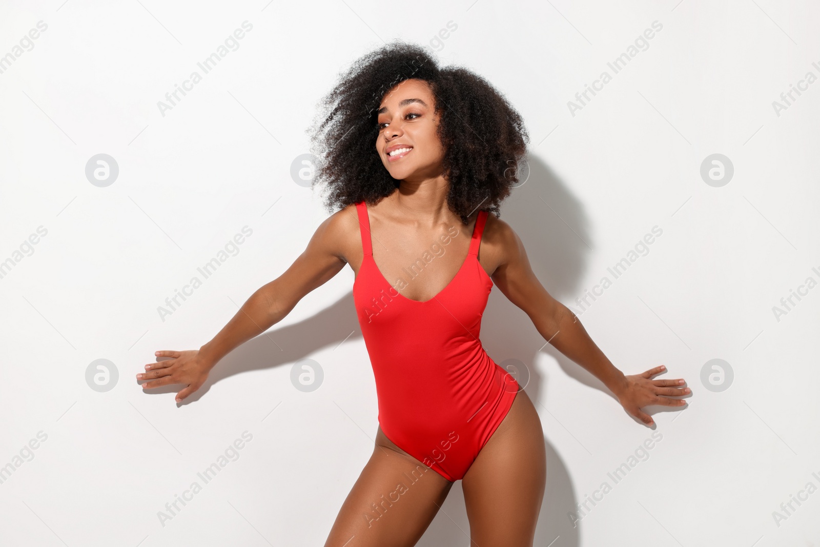 Photo of Beautiful woman in red one-piece summer swimsuit on white background