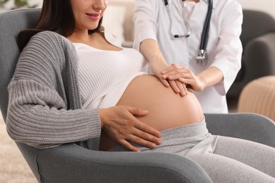 Photo of Doctor examining pregnant woman in clinic, closeup