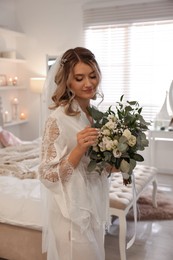 Happy bride with beautiful bouquet at home. Wedding day