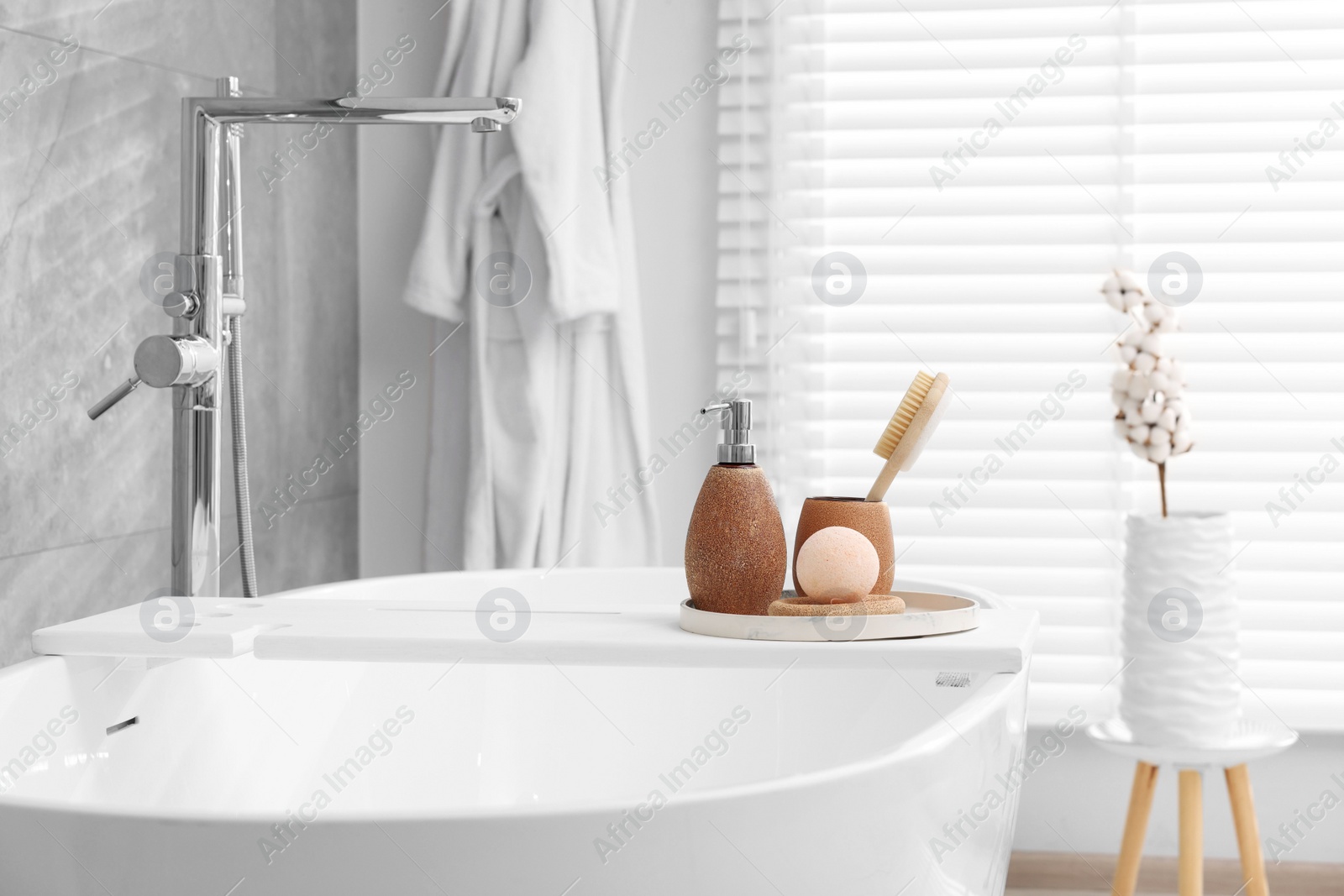 Photo of Different personal care products and accessories on bath tub in bathroom