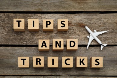 Photo of Phrase Tips and Tricks made with cubes on wooden table, flat lay