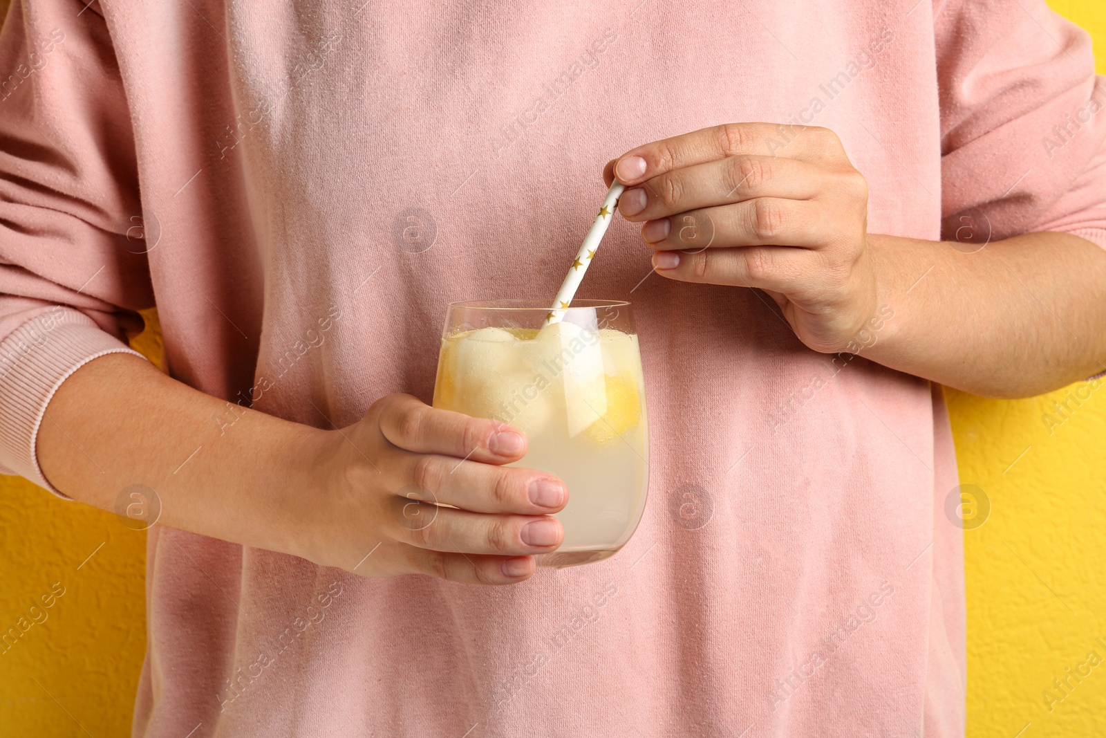 Photo of Woman holding glass of melon ball cocktail with straw, closeup