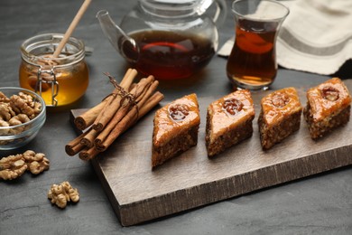 Delicious sweet baklava with walnuts and cinnamon on black table