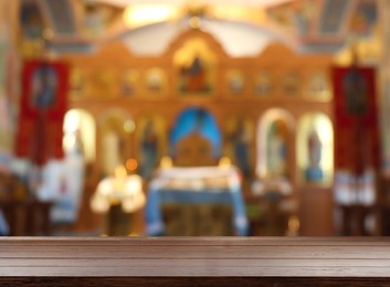 Image of Empty wooden table and blurred view of beautiful church interior, space for text
