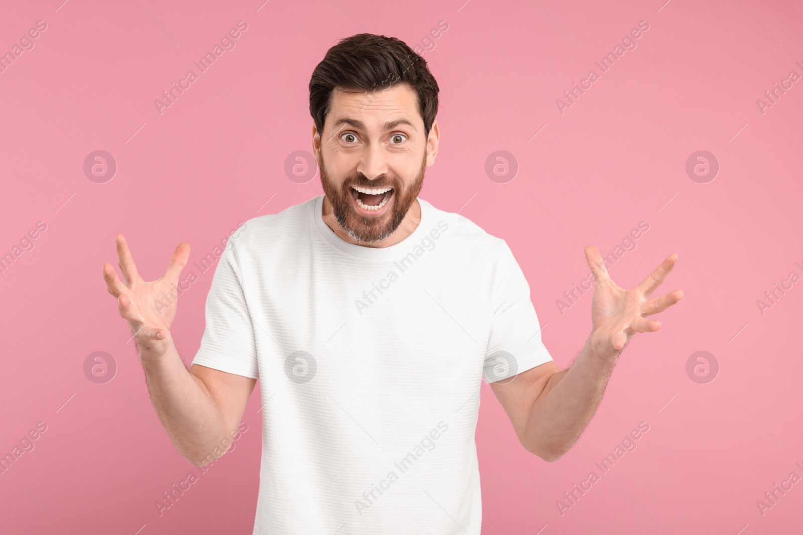 Photo of Portrait of surprised man on pink background